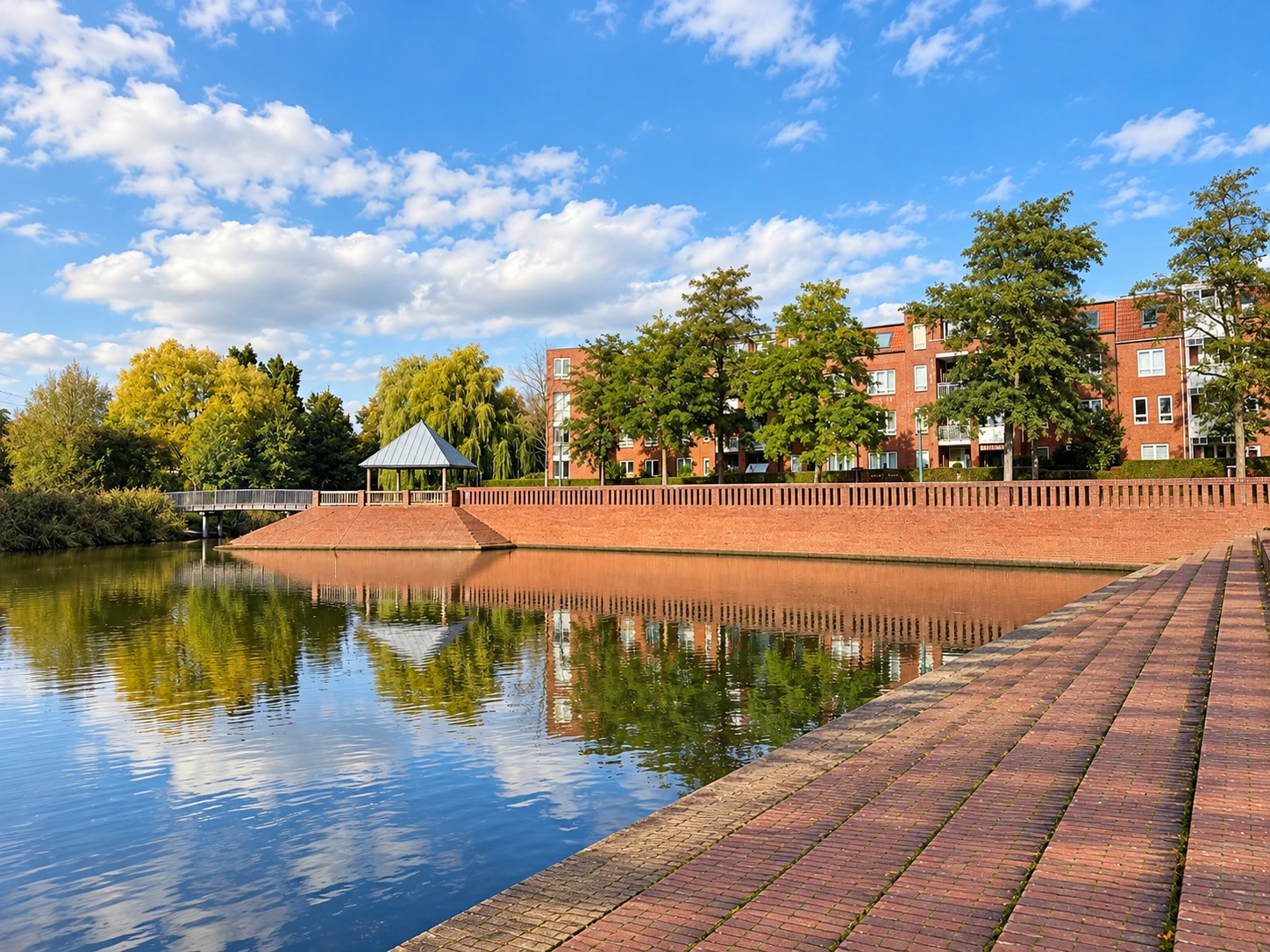 Grachtenplatz in Hamburg-Neuallermöhe mit Fleet, roter Klinkerbebauung und Uferpromenade.